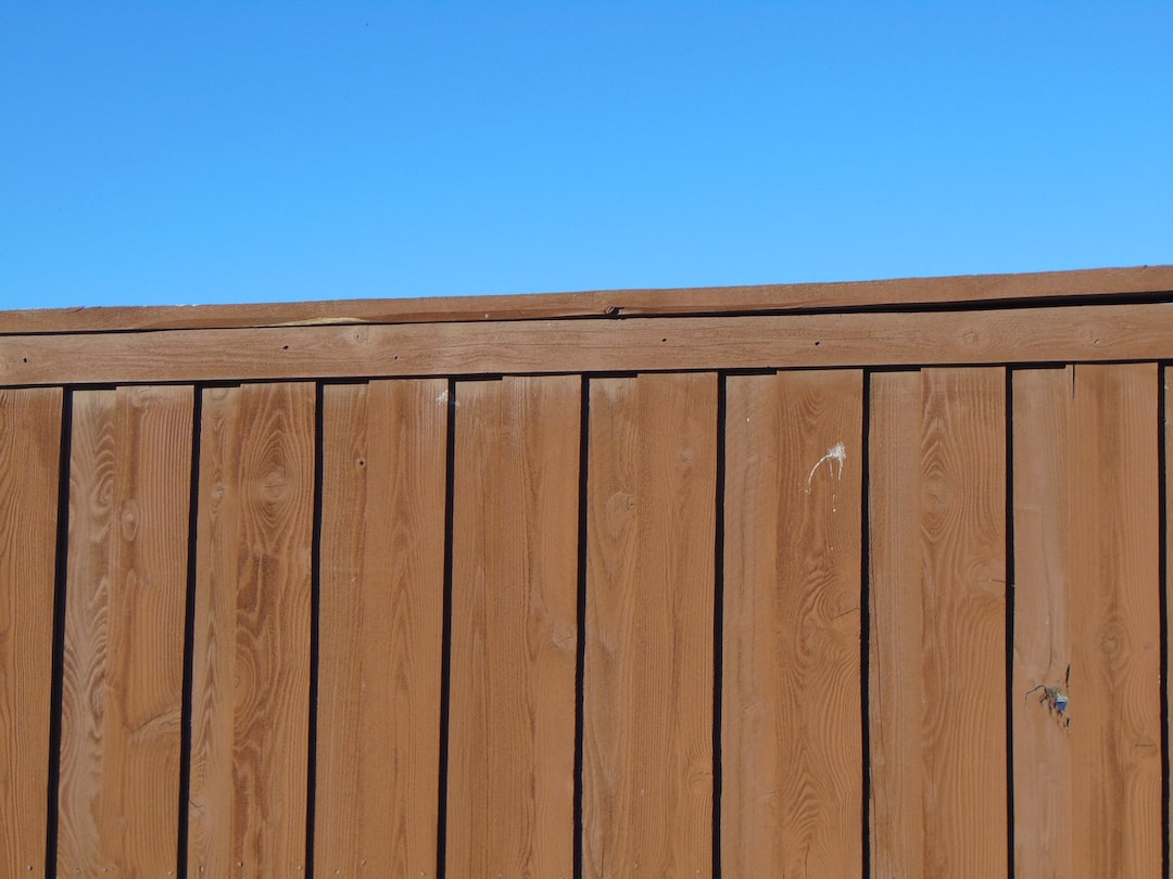 a wooden fence with a blue sky in the background 2